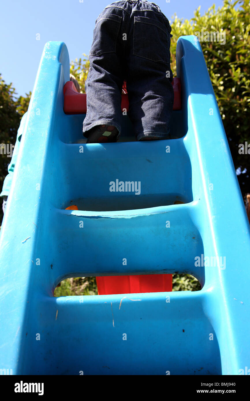 toddler playing on a slide Stock Photo