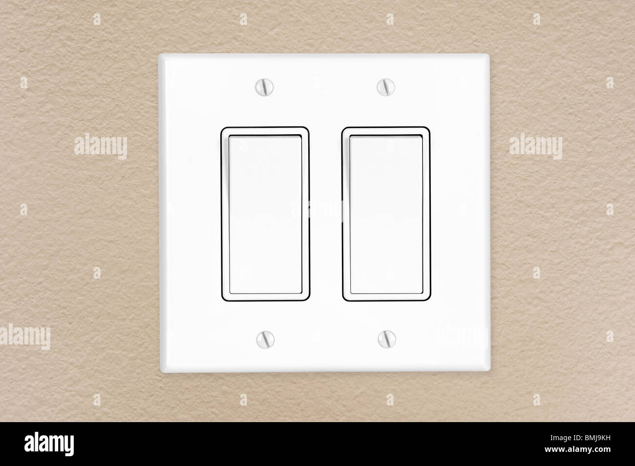 A brand new modern electrical toggle light switch on a freshly painted wall. Stock Photo