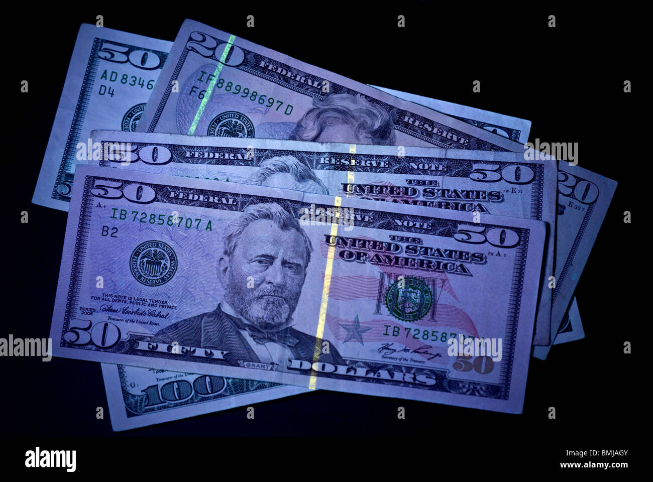 United States currency, under a UV light to show anti-counterfeit technology. Stock Photo