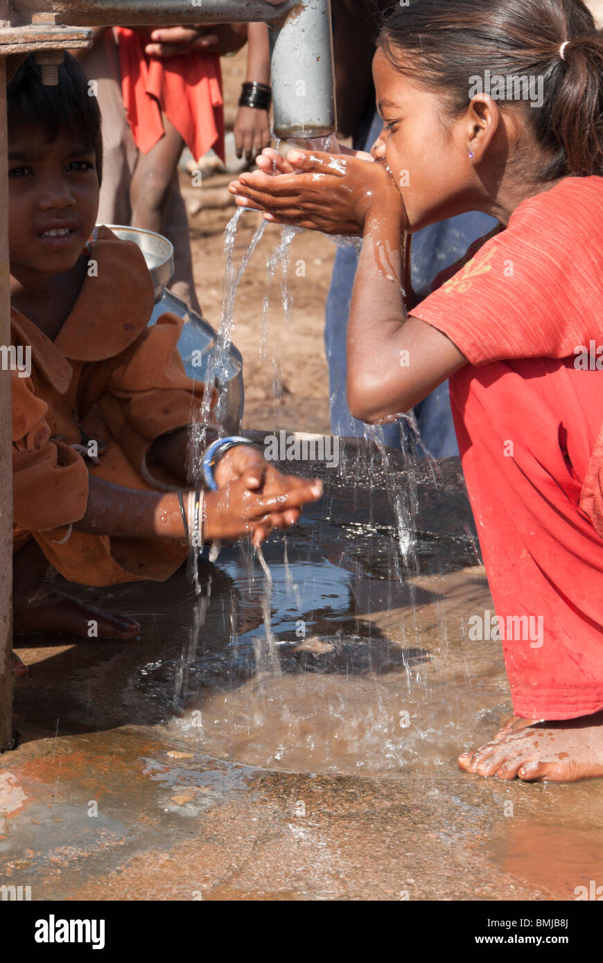 Village children drink from a well in a tribal village near Gwalior, India Stock Photo