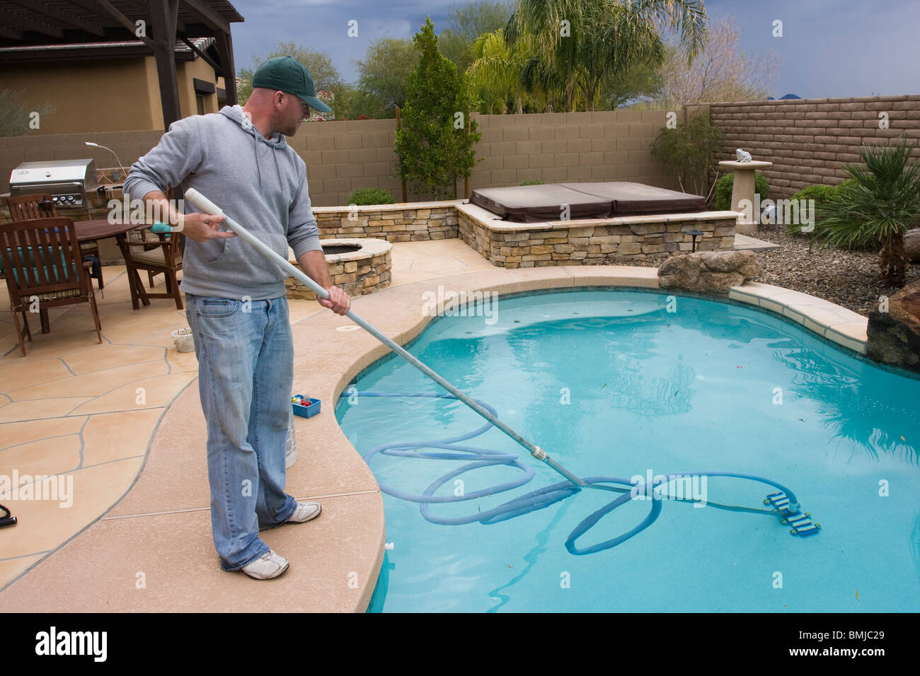 Man cleaning and vacuuming swimming pool Stock Photo - Alamy