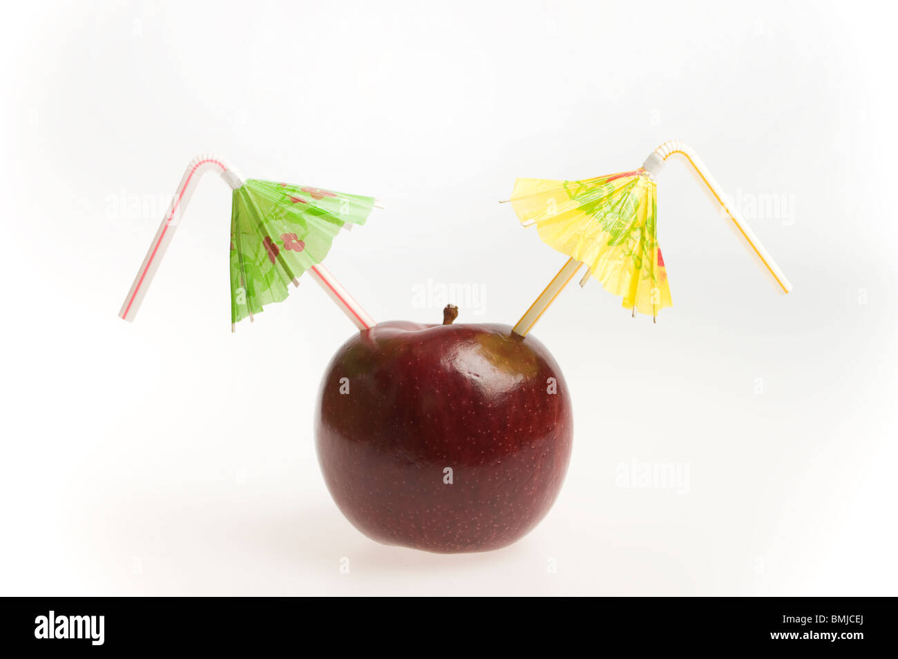 apple with two straws and umbrellas Stock Photo