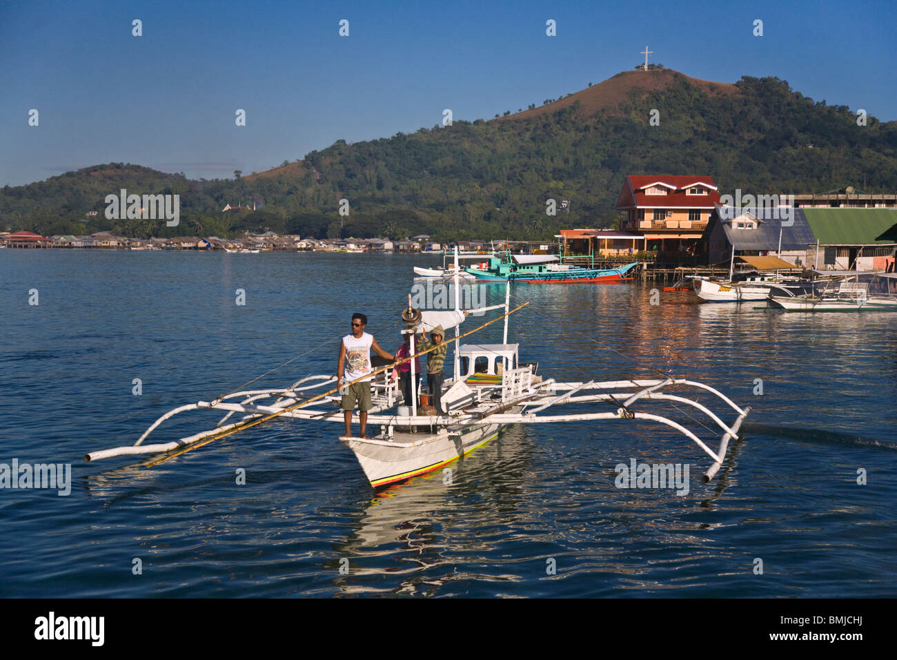 A small boat and CORON TOWN on BUSUANGA ISLAND in the CALAMIAN GROUP - PHILIPPINES Stock Photo