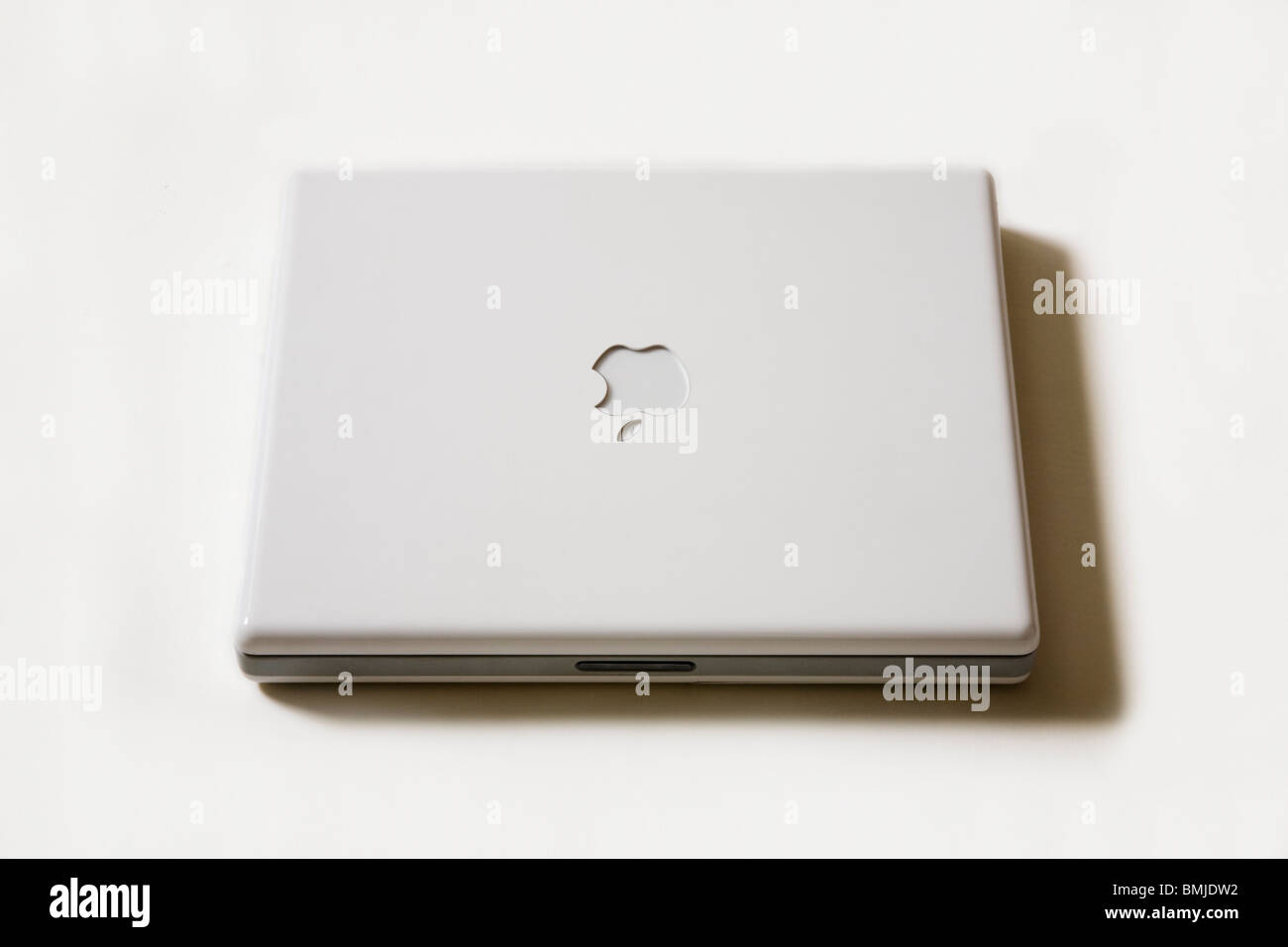 A closed Apple iBook G4 laptop / lap top computer showing the Apple logo. Stock Photo