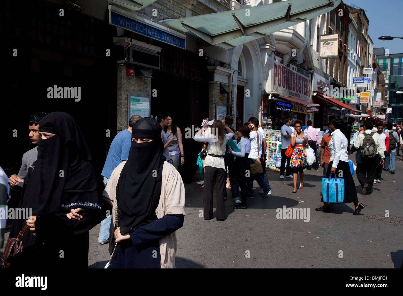 People from various ethnic backgrounds (mainly Muslim) around the market on Whitechapel High Street in East London. Stock Photo