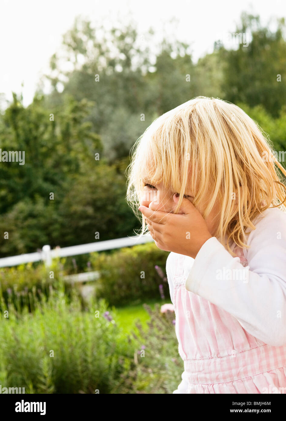 Little girl standing in garden Stock Photo