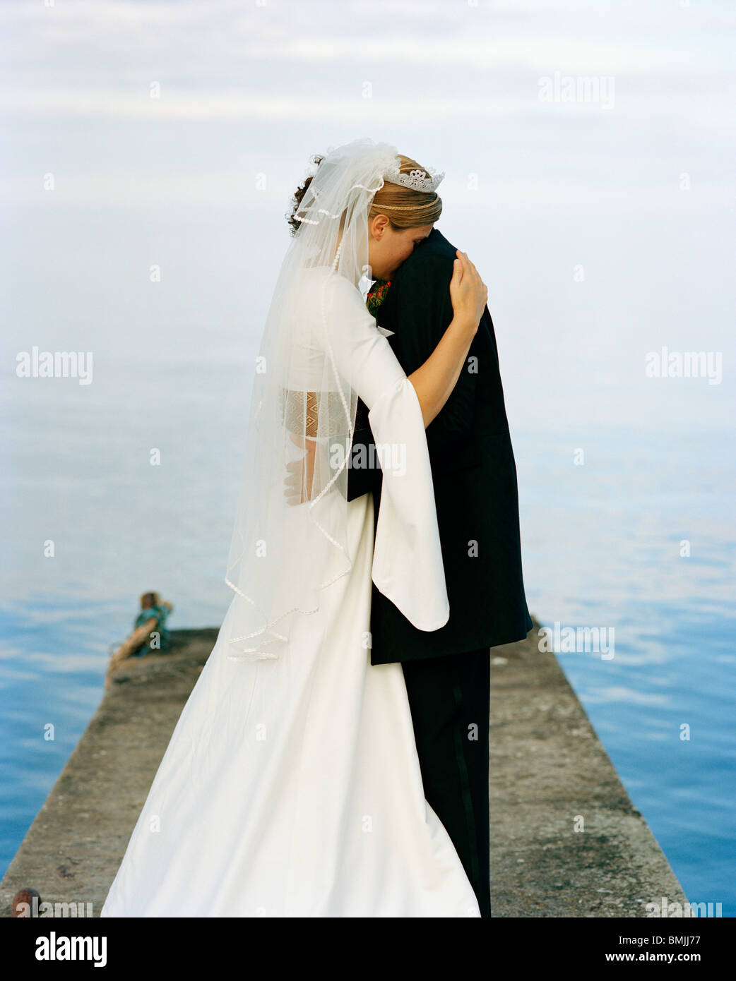 Scandinavia, Sweden, Oland, Groom and bride embracing on jetty Stock Photo