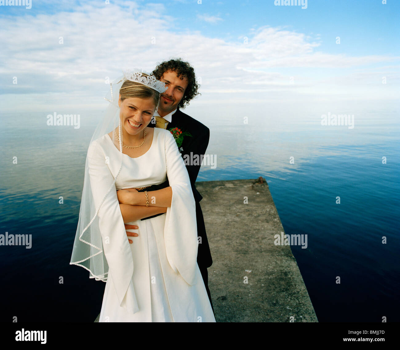 Scandinavia, Sweden, Oland, Groom and bride embracing on jetty, smiling, portrait Stock Photo
