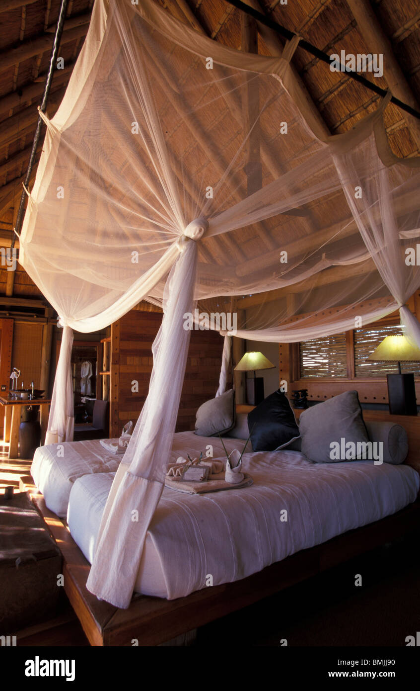 Africa, Botswana, Okavango Delta. Bed with mosquito netting at Jao Camp