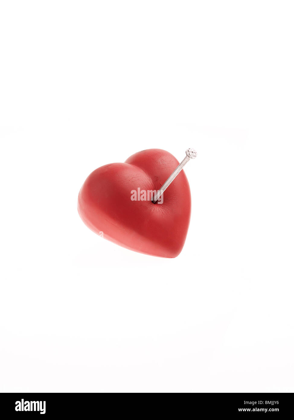 Nail in a red heart. Stock Photo