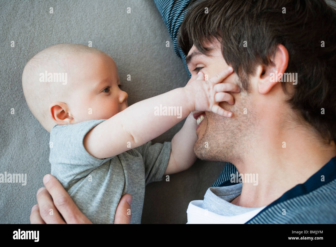 Baby touching fathers face Stock Photo Alamy