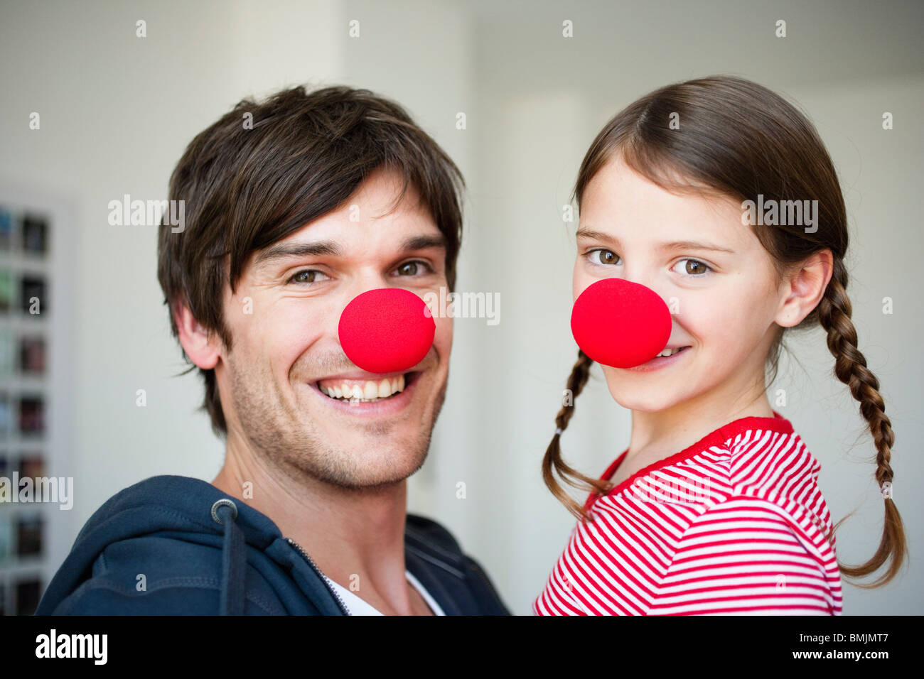 Father and girl wearing red noses Stock Photo