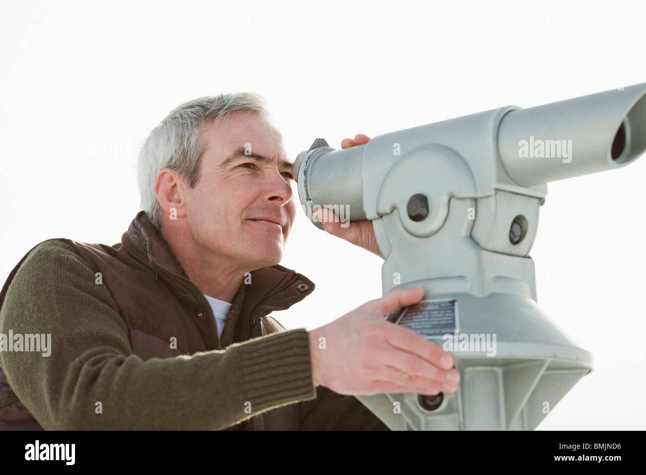 Man looking through a telescope Stock Photo