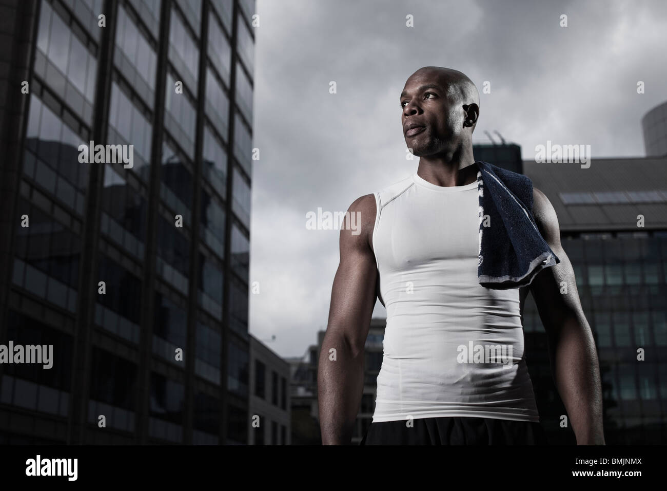 Fit man wearing sportswear backgrounded by modern city buildings Stock Photo