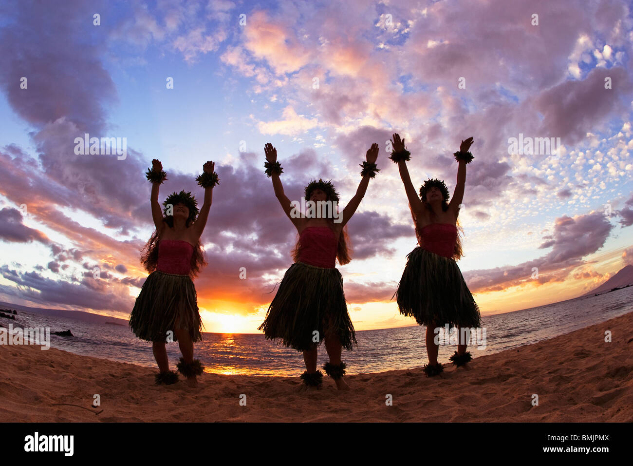 Three hula dancers at sunset at Palauea Beach, Maui, Hawaii, USA. Stock Photo