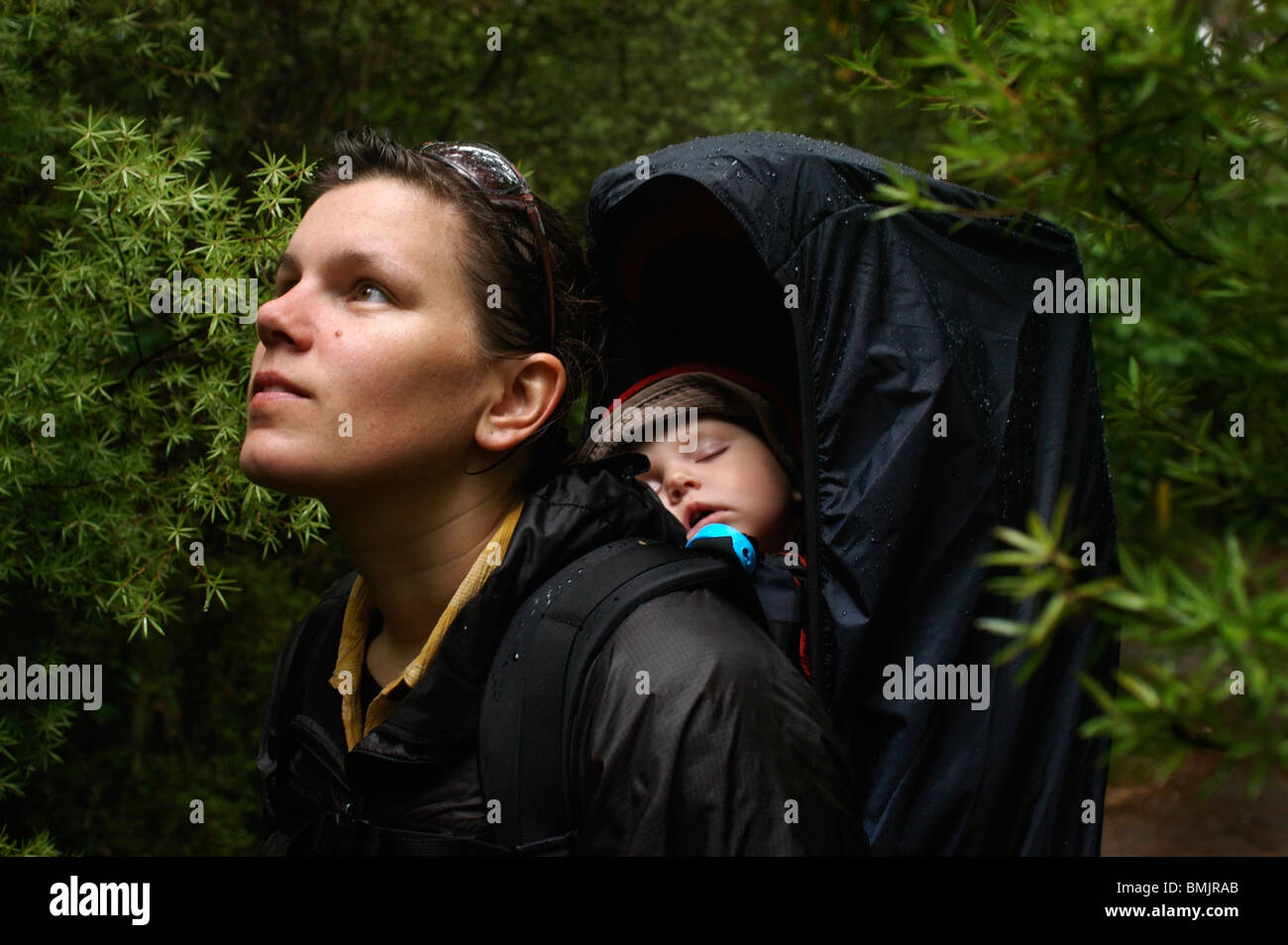 A woman with her sleeping baby in the forest Stock Photo