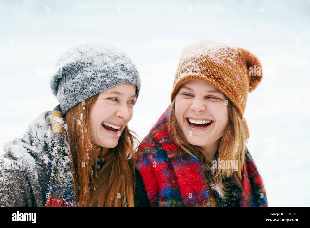 Two happy young women in snow Stock Photo - Alamy