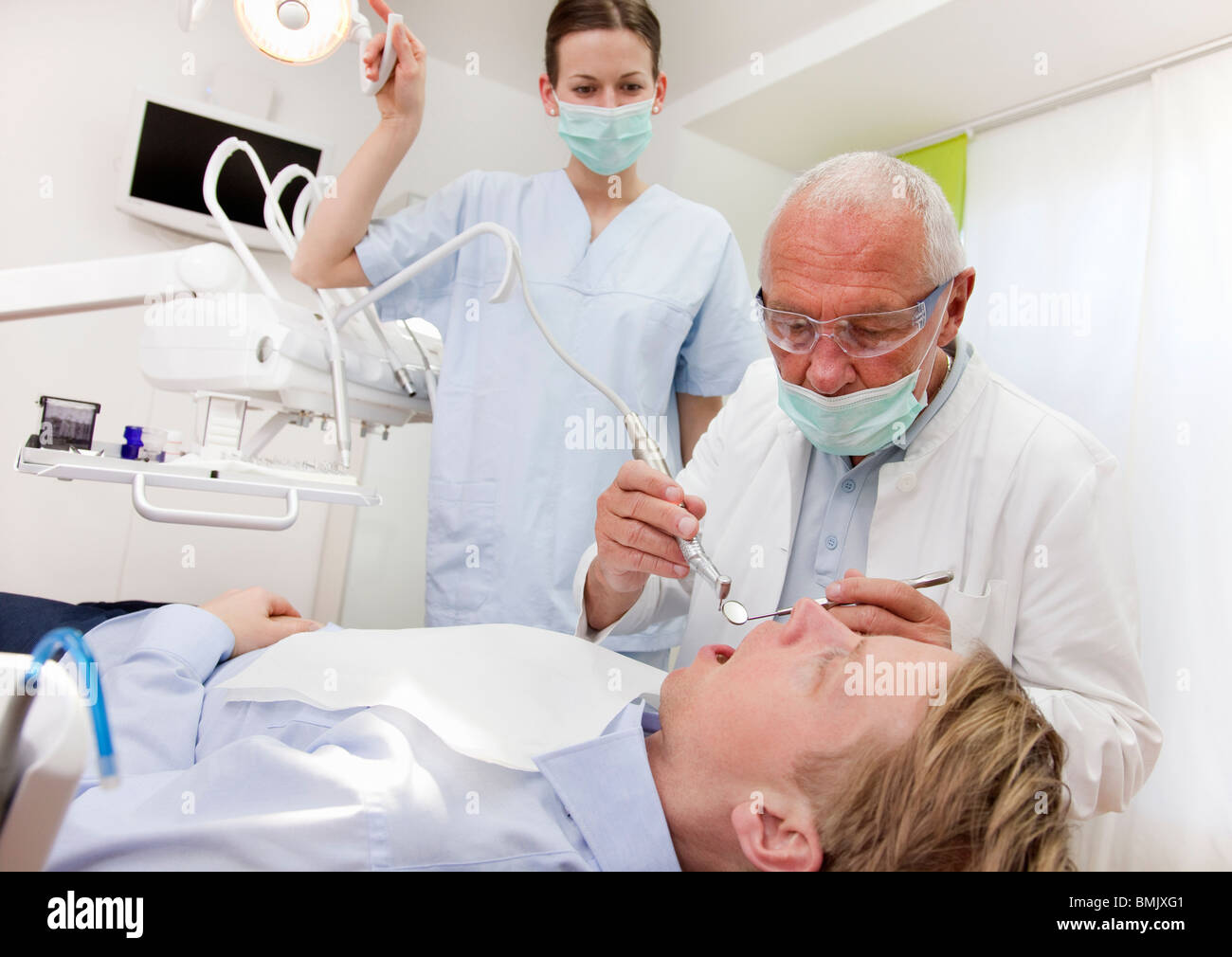 Dentist with patient in surgery Stock Photo