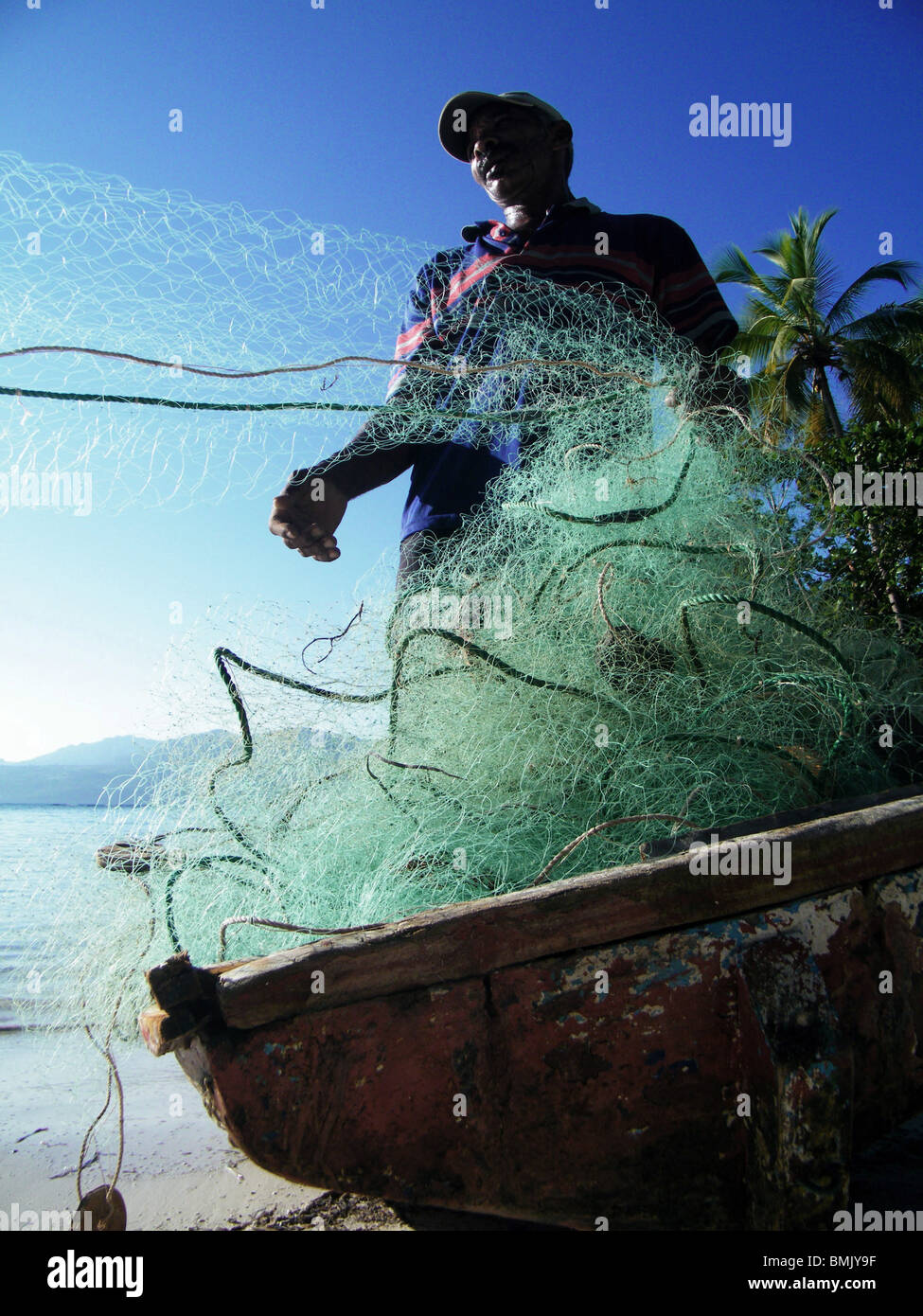 A fisherman mends his nets on La Playita beach, Dominican Republic Stock Photo