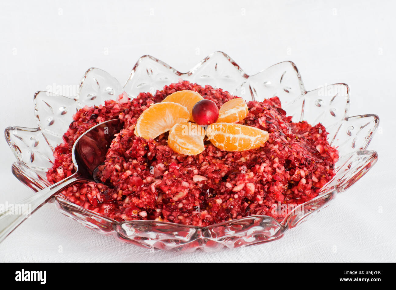 Bowl of fresh cranberry sauce topped with mandarin orange garnish. Stock Photo