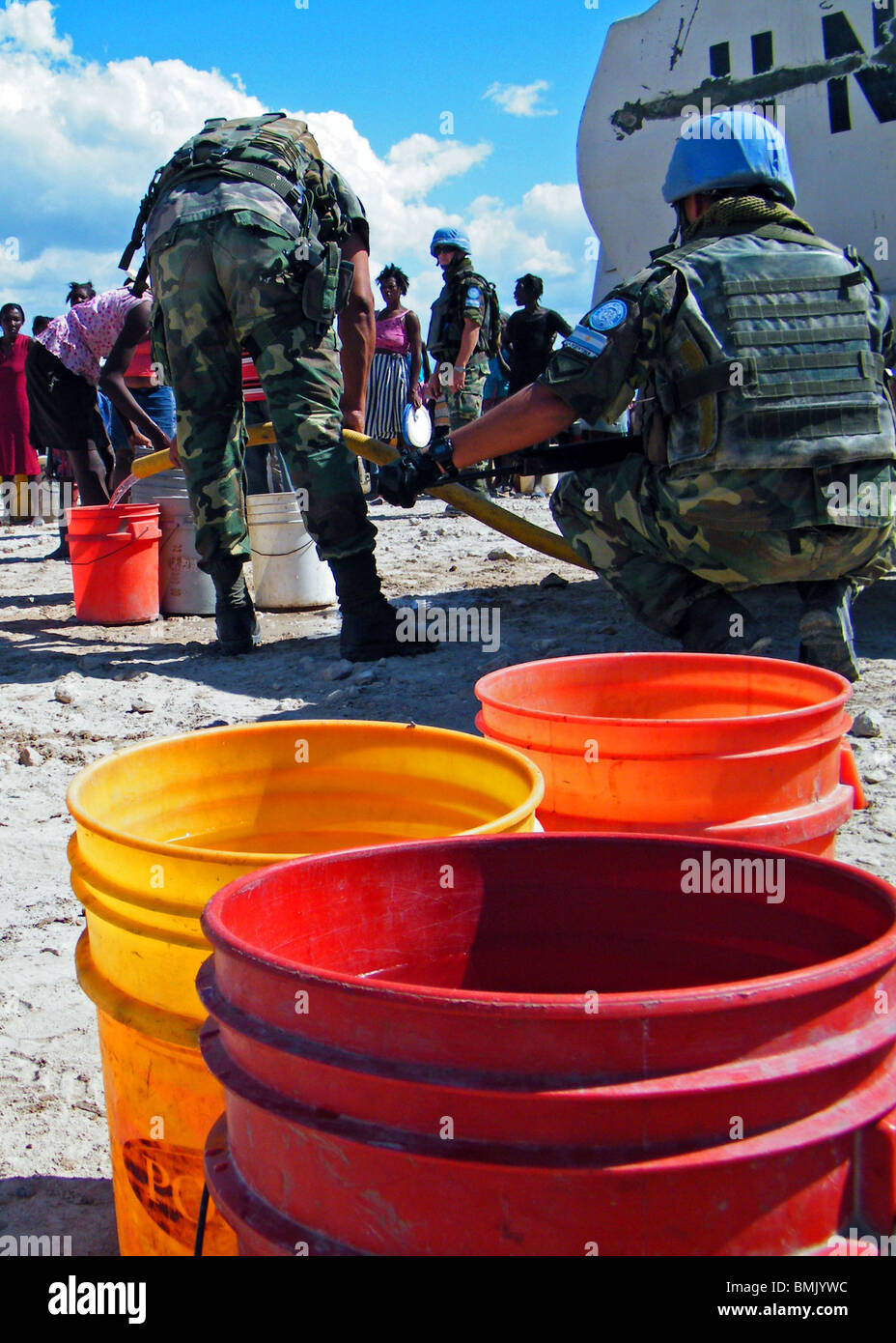 United Nations peacekeepers fill buckets with drinking water at an aid distribution point outside Gonaives, Haiti Stock Photo