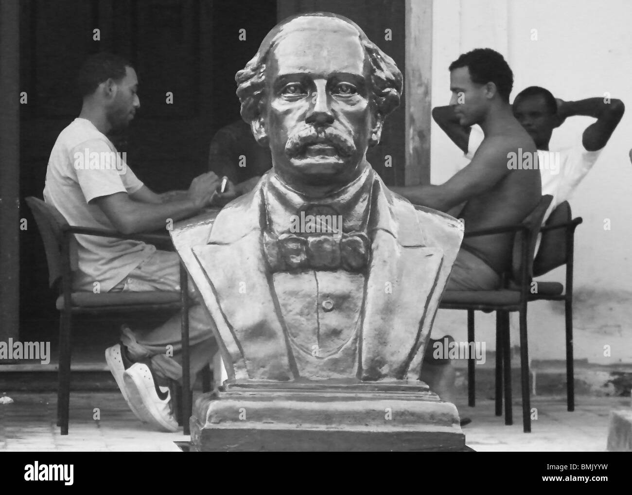 Men play a game behind a bust of independence hero Juan Pablo Duarte in Puerto Plata, Dominican Republic Stock Photo
