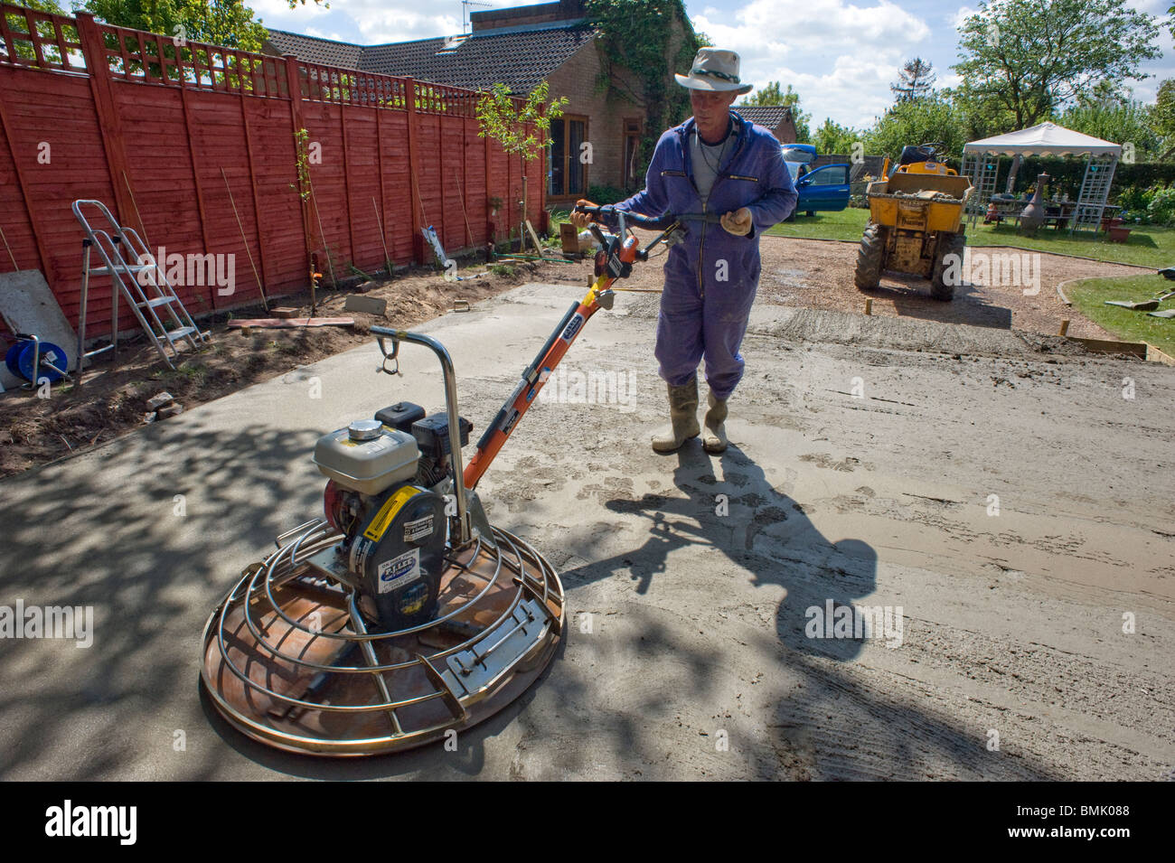 man leveling concrete base with power float Stock Photo Alamy