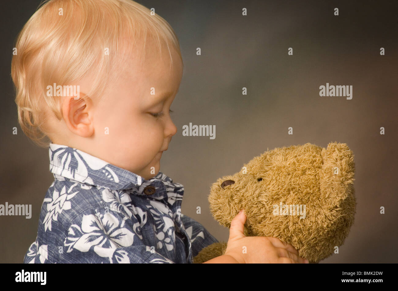 Close up of a baby boy holding his teddy bear Stock Photo - Alamy