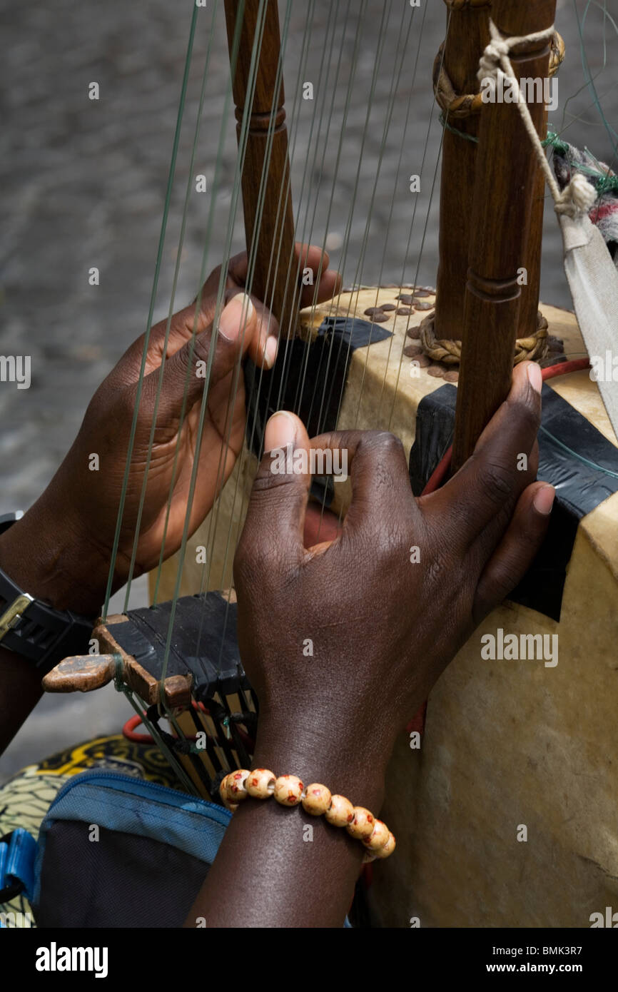 Black hands playing the strings of a 21 string Kora harp-lute, an African musical instrument, Rome, Italy Stock Photo