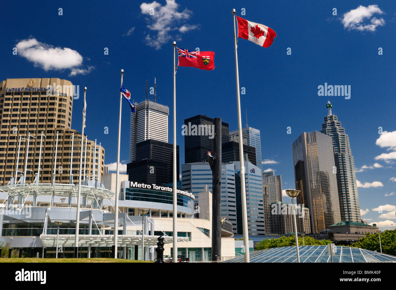 Canada and Ontario Flags at the Metro Toronto Convention Centre with bank and office highrise towers downtown Toronto with blue sky Stock Photo