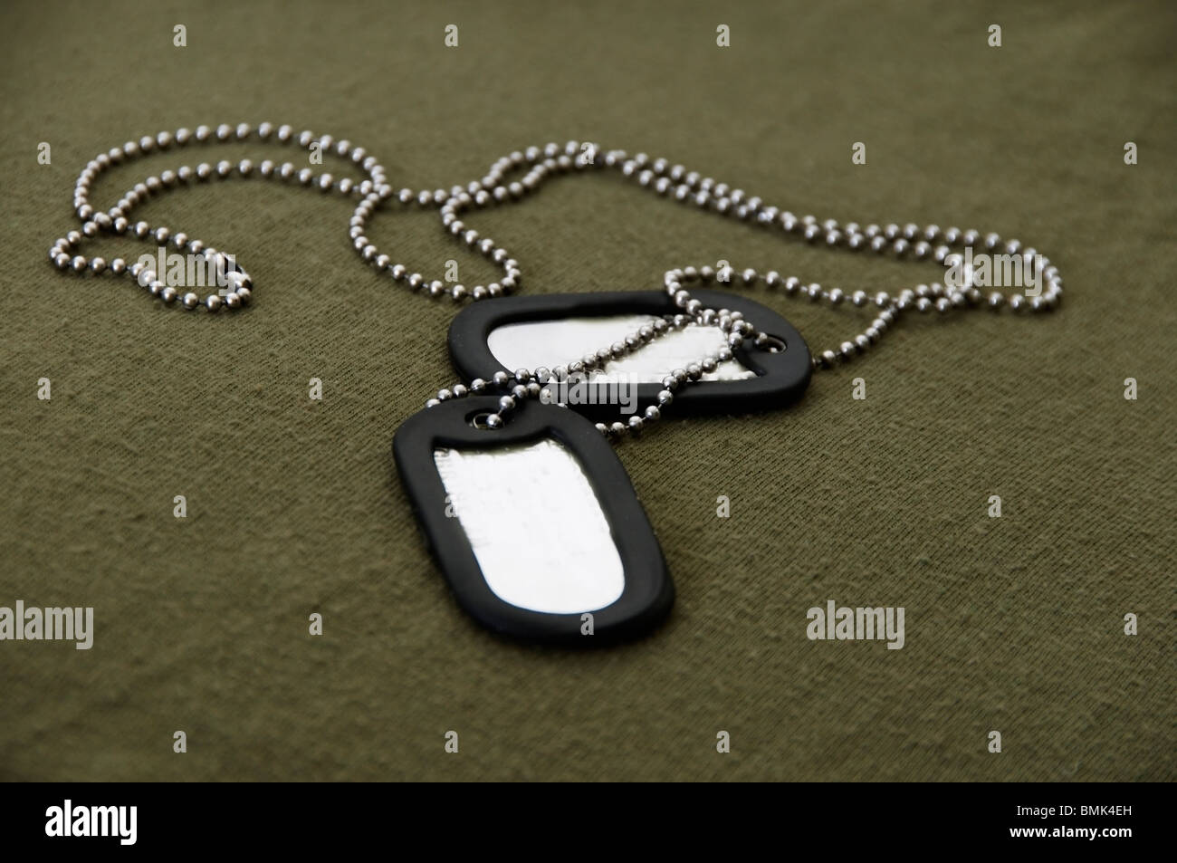 Military dog tags and chain on green tee shirt background Stock Photo -  Alamy