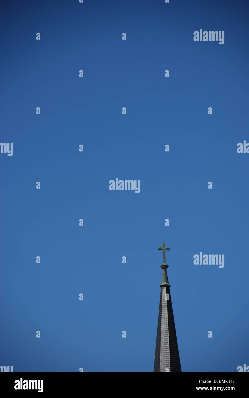 Church steeple with cross against blue sky. Stock Photo