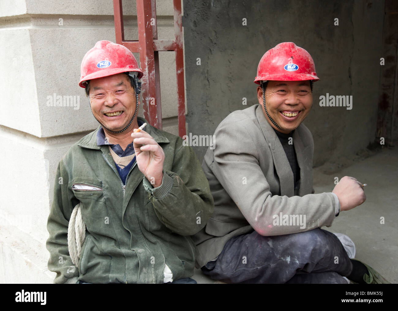 Two construction workers taking a cigarette break, Shanghai, China Stock Photo