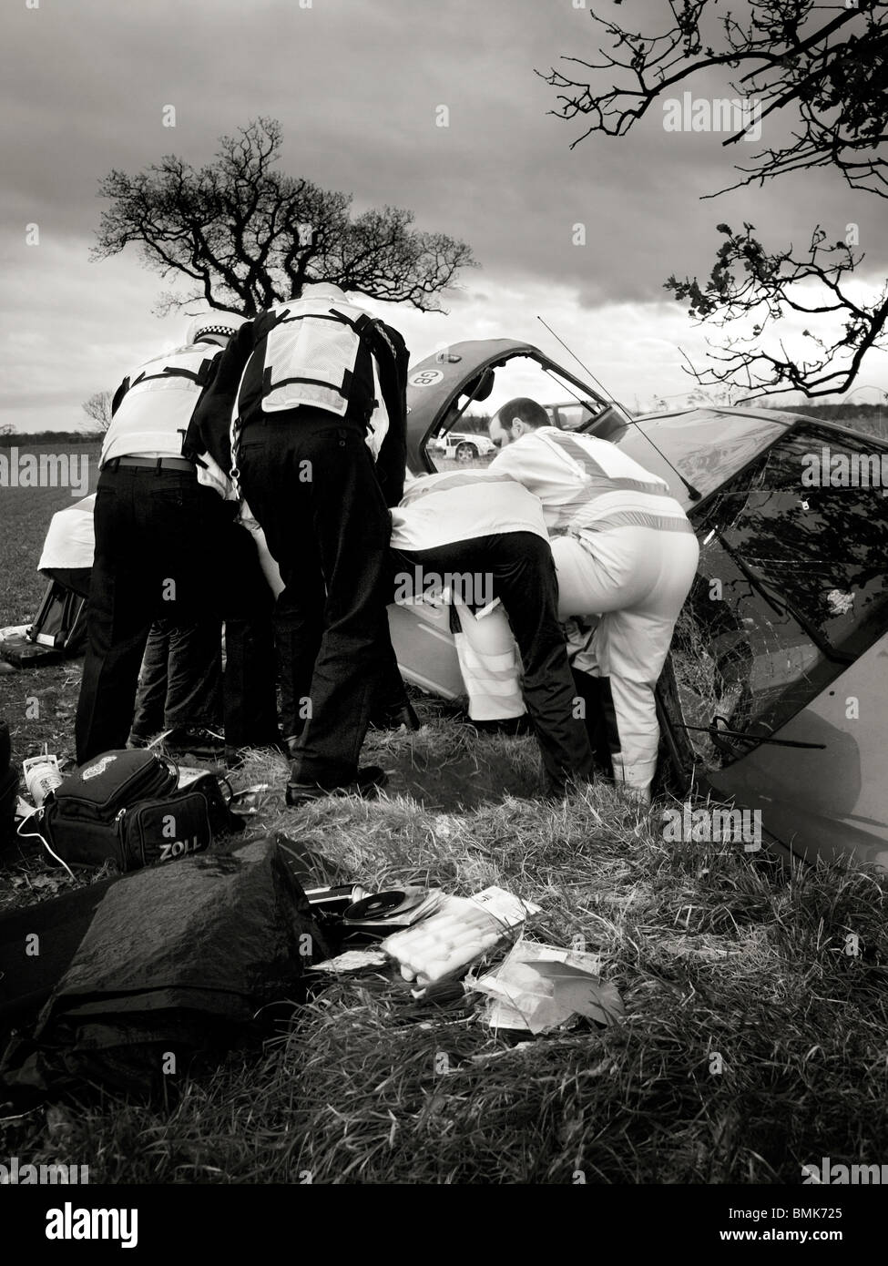 police and air ambulance paramedics work together to pull injured patient from car Stock Photo