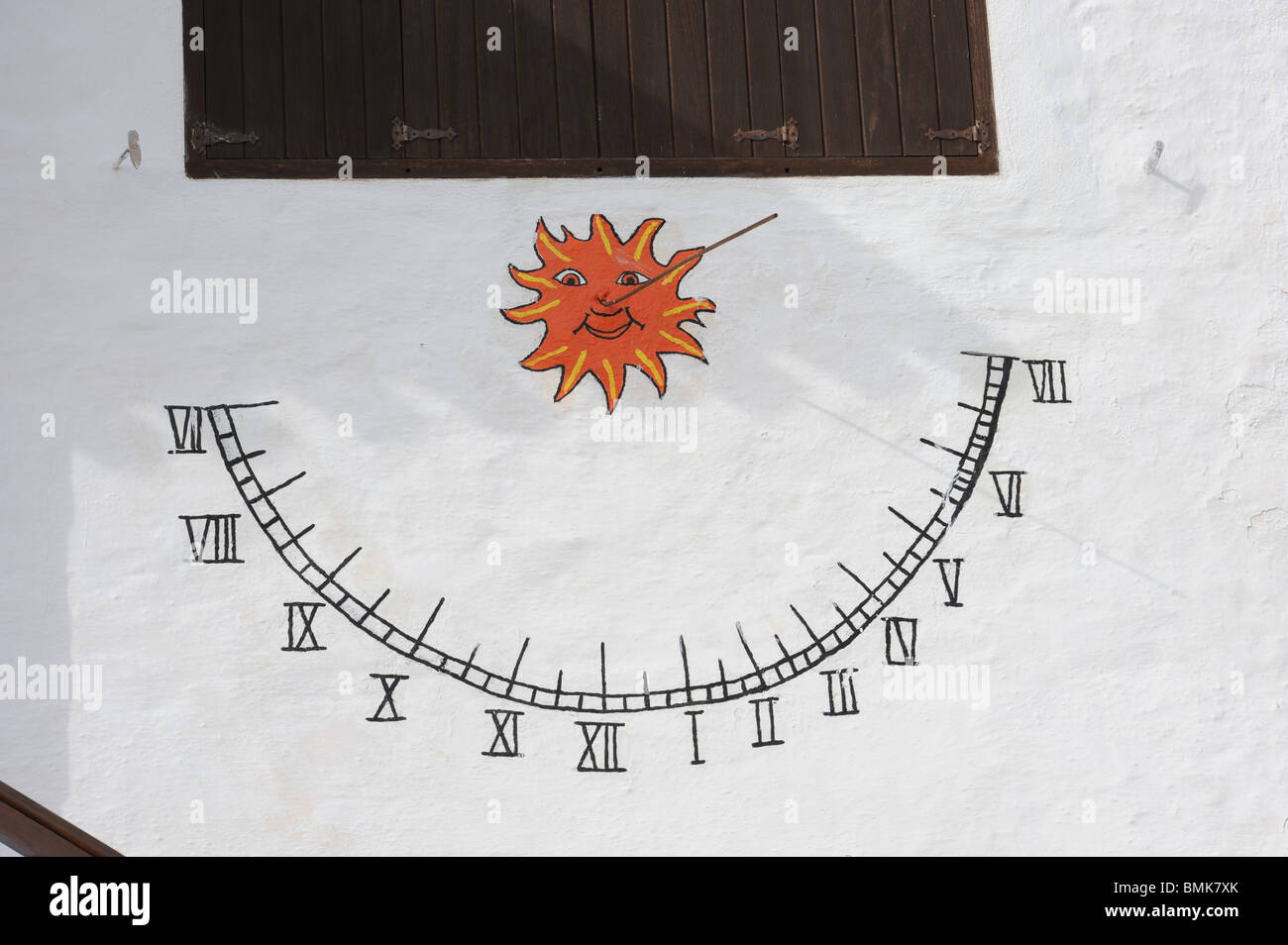 Sundial on white wall. The time is 5.45. Binibeca Vell, Menorca, Baleraric Islands, Spain Stock Photo