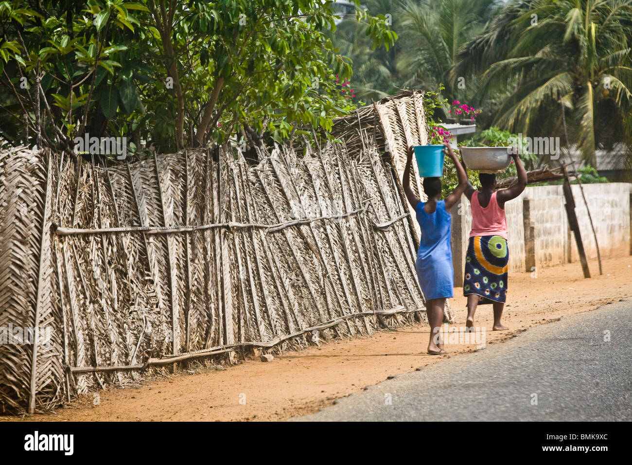 Africa, West Africa, Ghana, Coastal Road. Women carrying water buckets