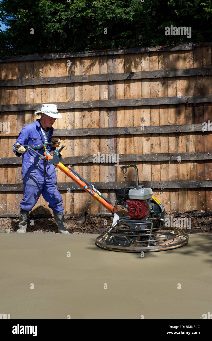 man levelling concrete base with power float Stock Photo