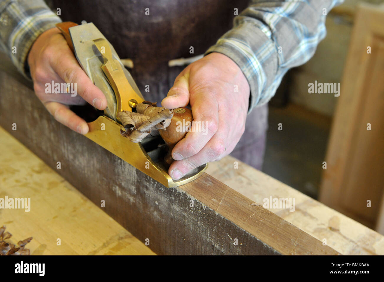 Carpenter crafting wood using a traditional plane Stock Photo