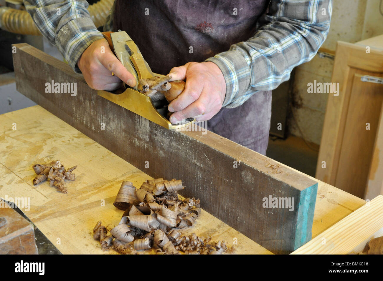 Carpenter crafting wood using a traditional plane Stock Photo