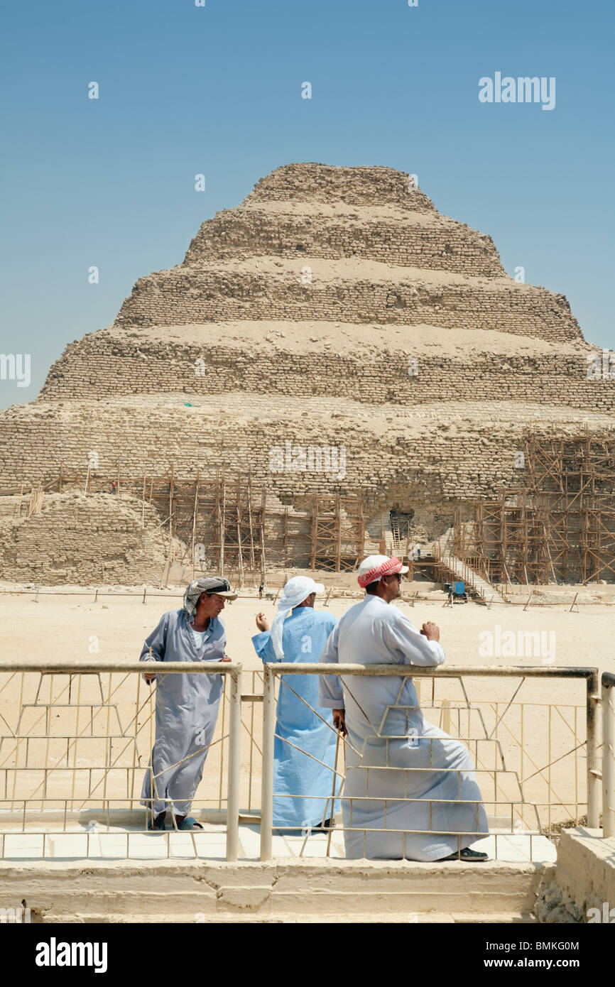 Three Egyptian men in front of the Step Pyramid of Djoser at saqqara, Egypt Stock Photo