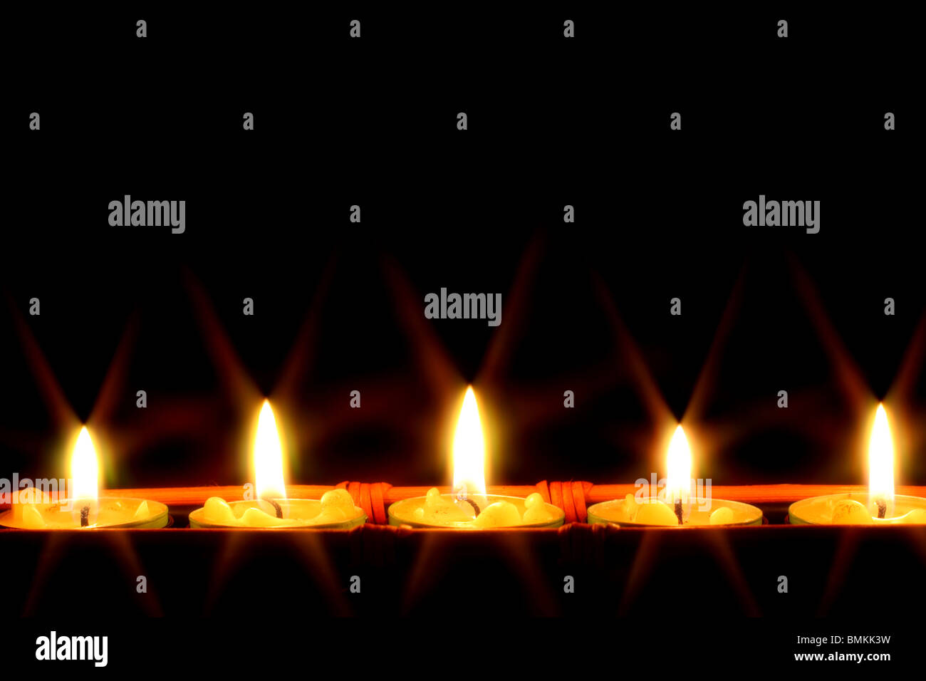 Row of candles on black background Stock Photo - Alamy