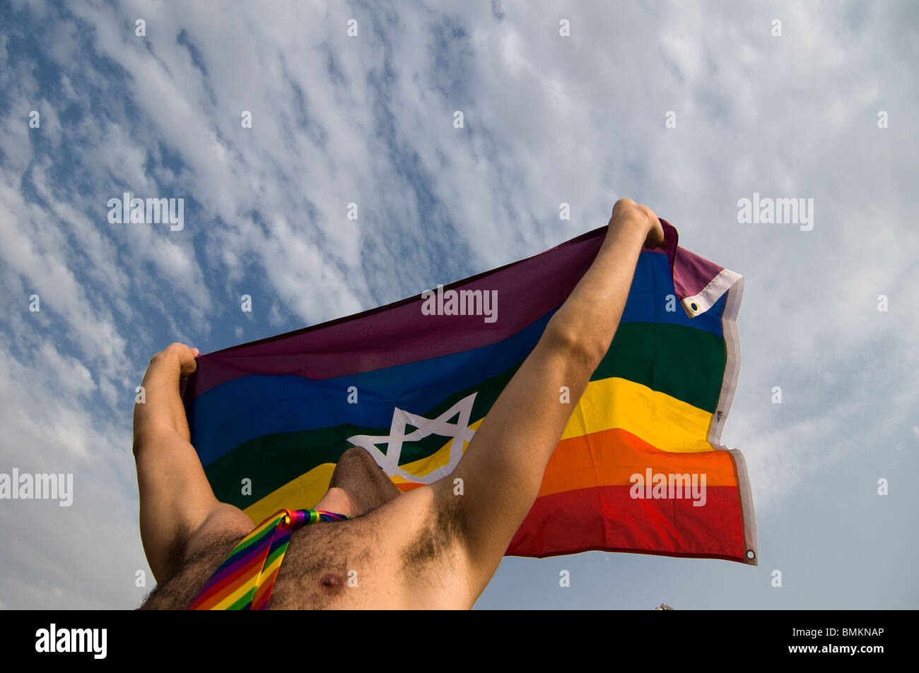 An Israeli man wave proudly the rainbow flag symbol of LGBTQ Pride bearing the Jewish Star of David at the annual LGBT Tel Aviv pride parade also called 'Love Parade' as part of the international observance of Gay Pride Month. Israel Stock Photo