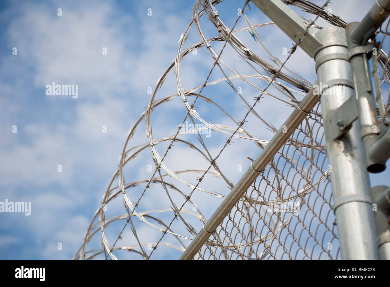 Florida - Feb 2009 - Stainless steel razor wire spirals over chain link fence at correctional facility in central Florida Stock Photo