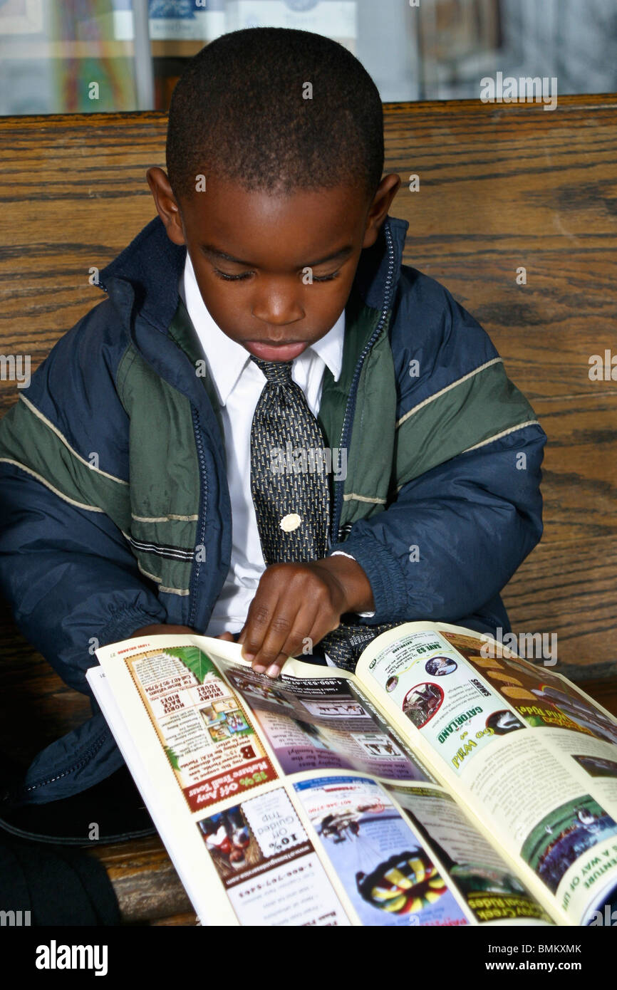 African American boy children child reading in front of Cracker Barrel Store and Restaurant .Florida United States  MR  © Myrleen Pearson Stock Photo