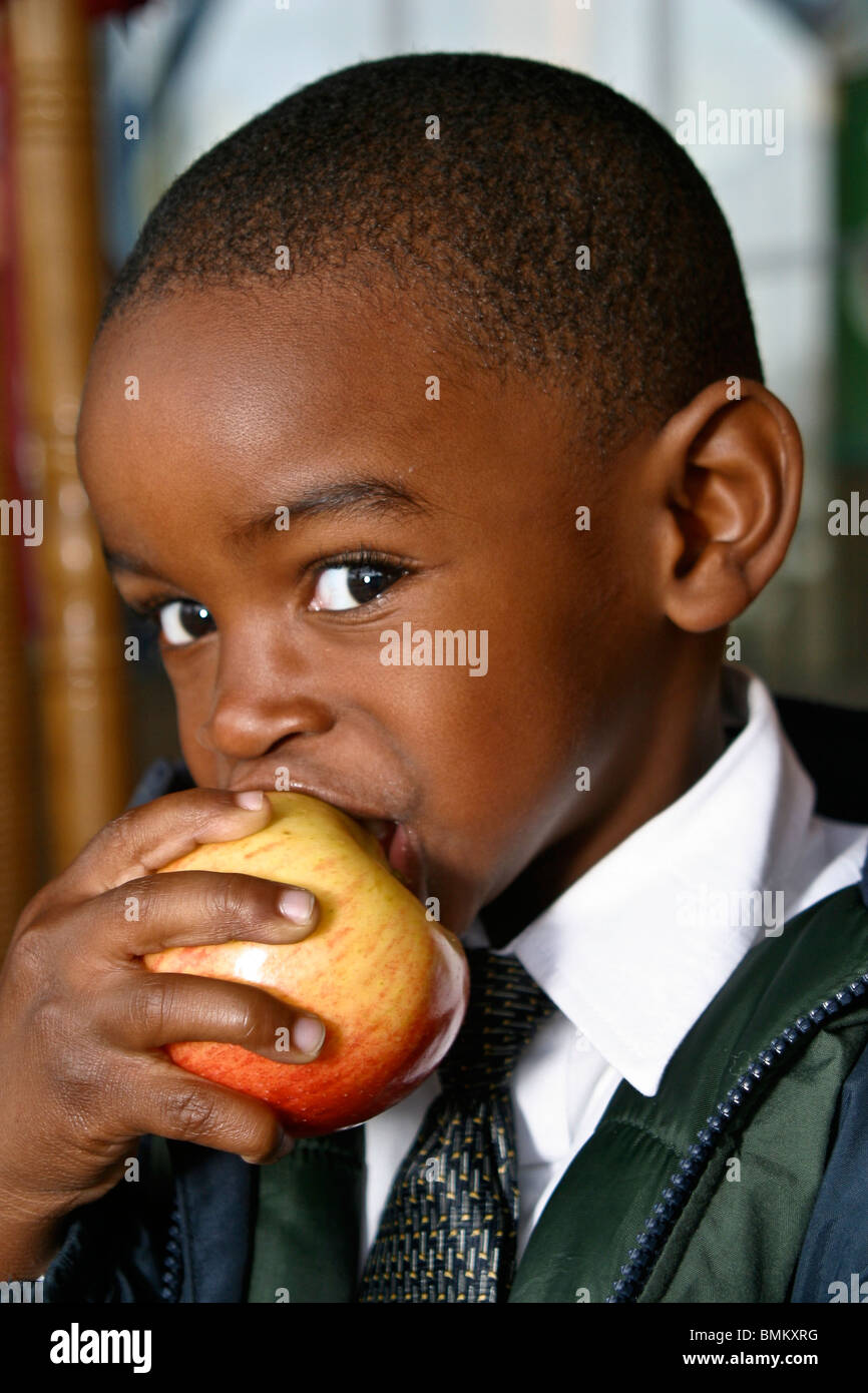5-7 year old olds African American boy eating apple in front of Cracker Barrel Store and Restaurant in Florida MR  © Myrleen Pearson Stock Photo