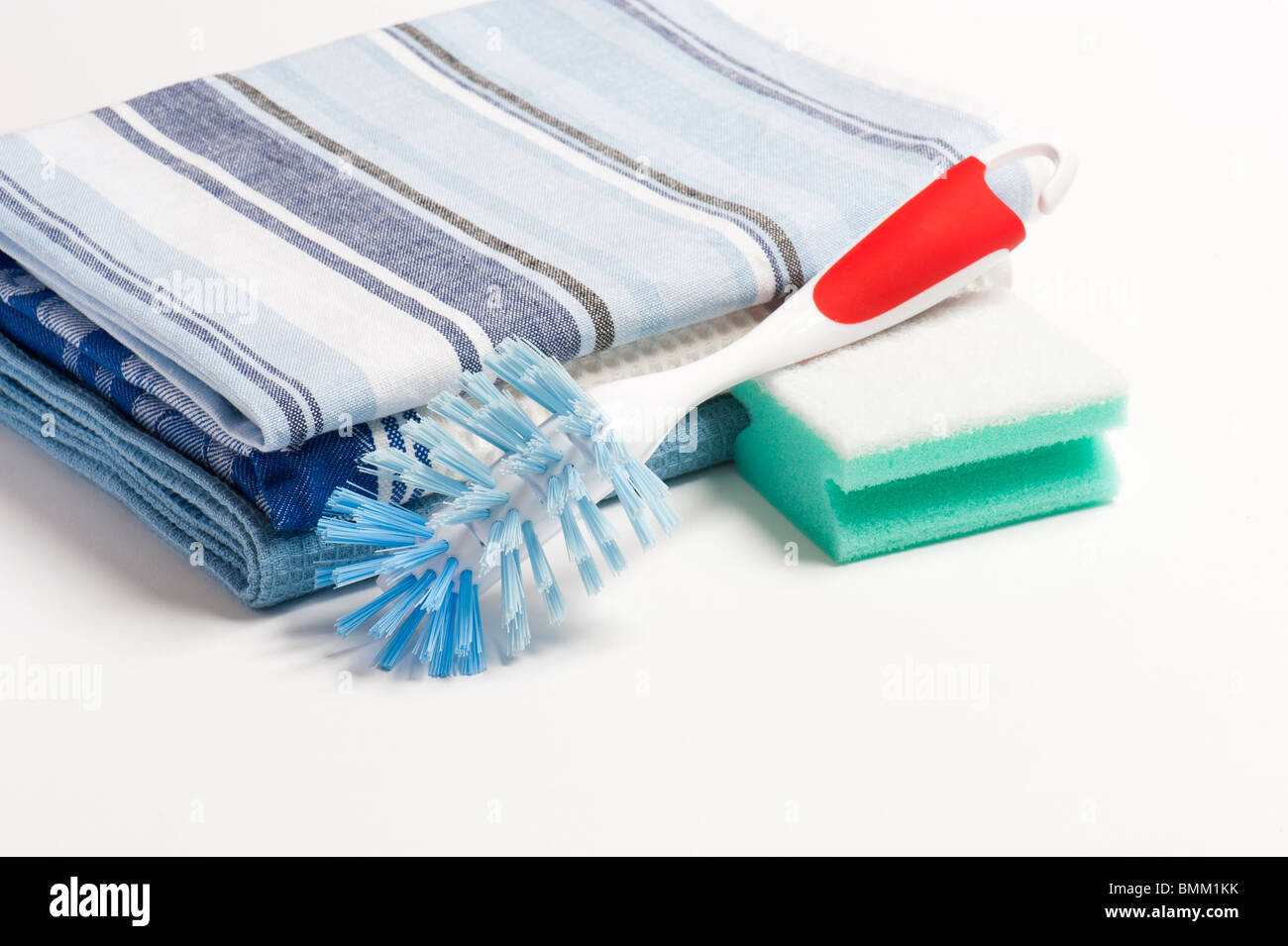 A Washing Up Brush, Scouring Pad and Three Folded Drying Cloths Stock Photo