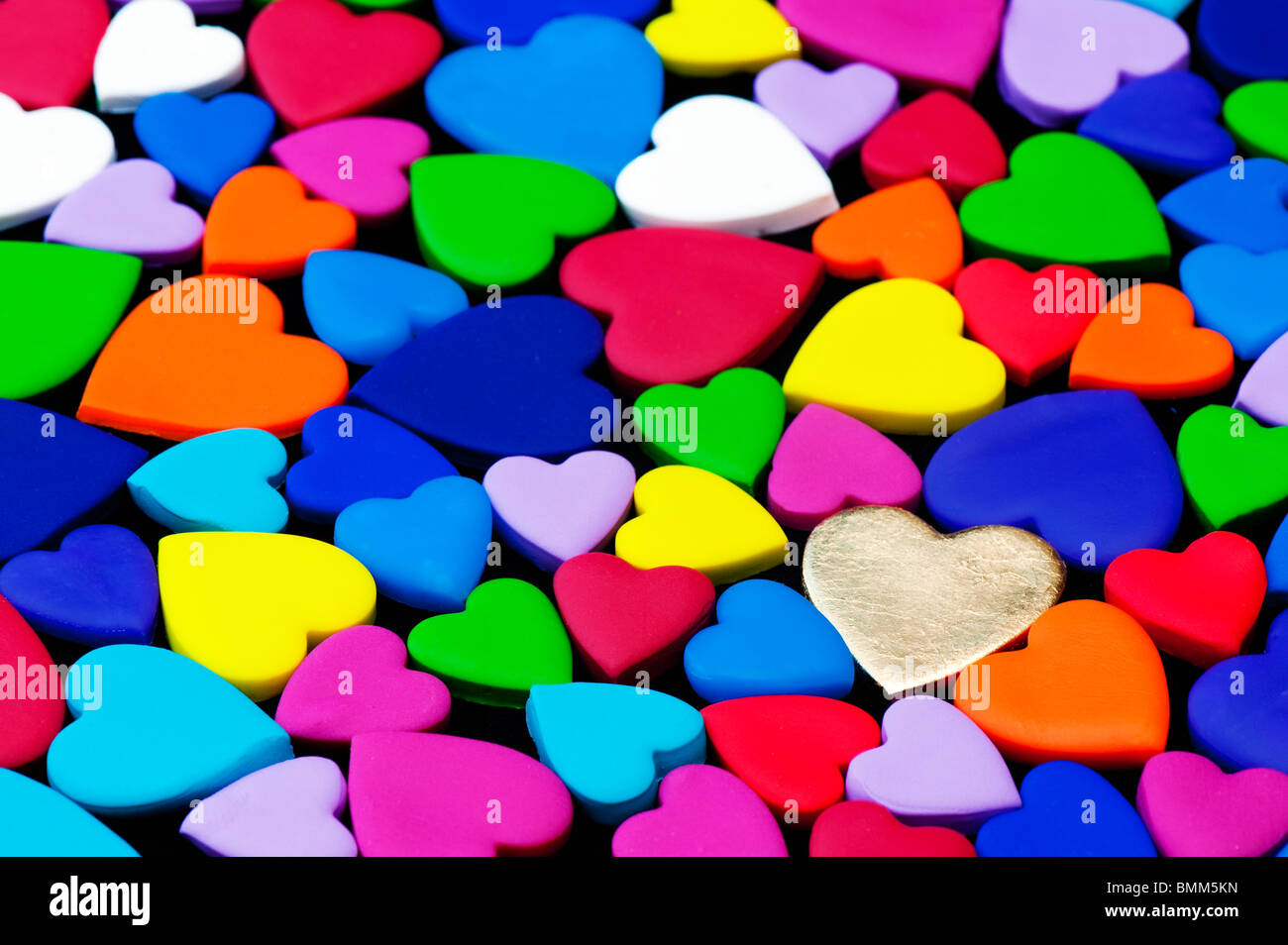 Multicoloured heart shape pattern against black background Stock Photo