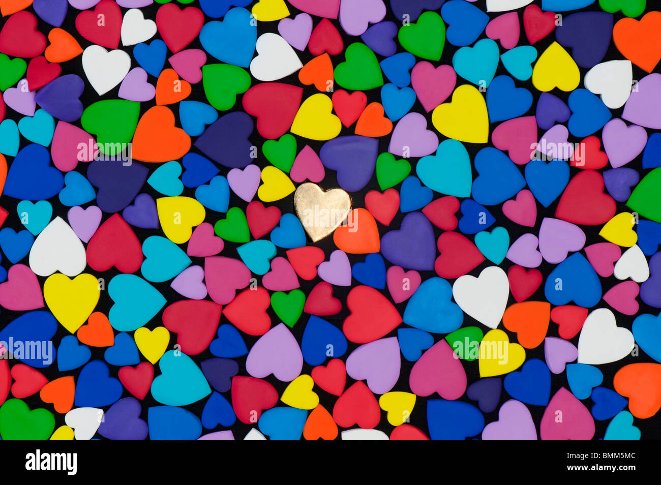 Multicoloured heart shape pattern against black background Stock Photo