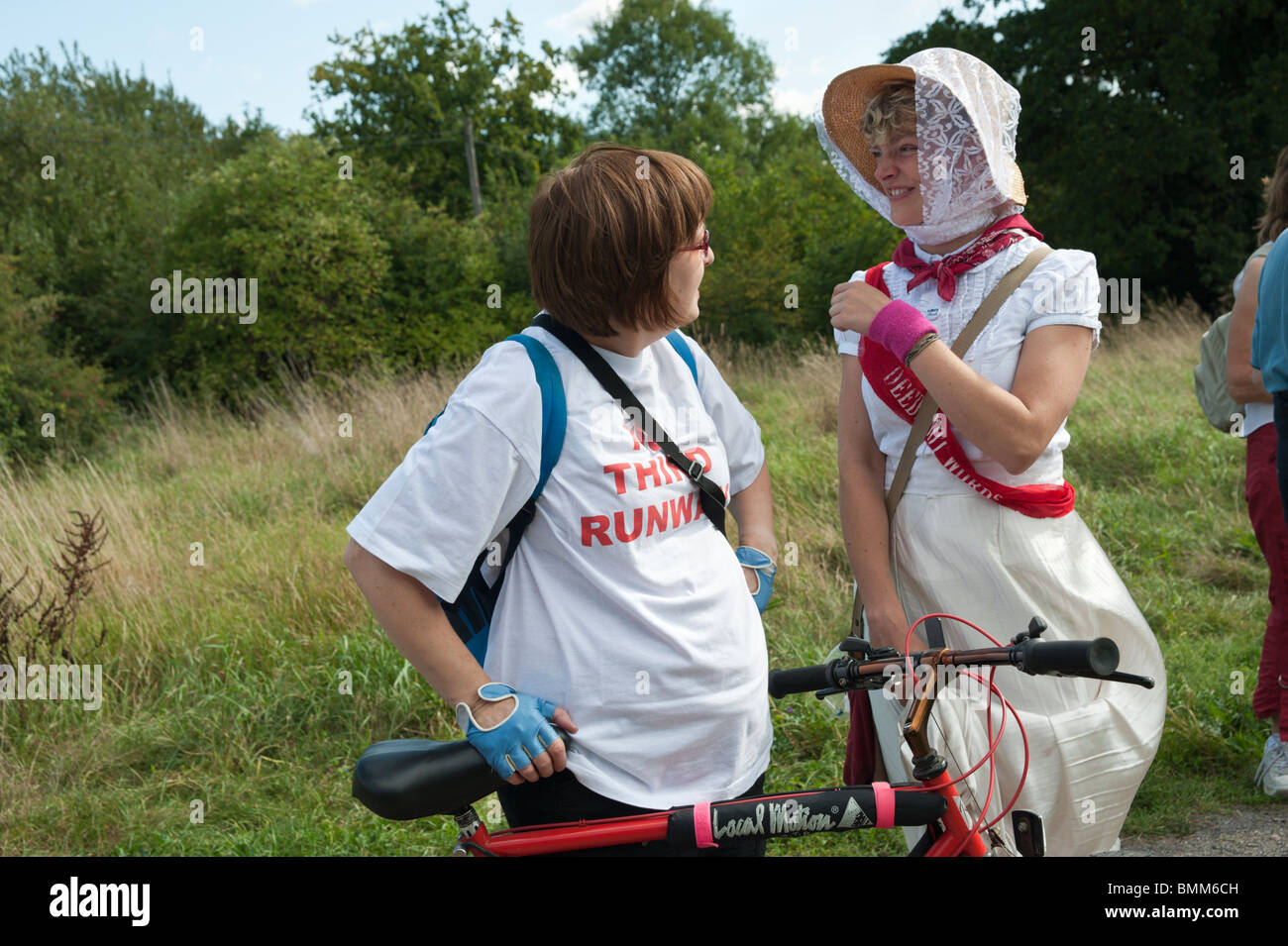 Tamsin Omond in Climate Rush suffragette dress talks to a No Third Runway cyclist on London Churches Environmental Network walk Stock Photo