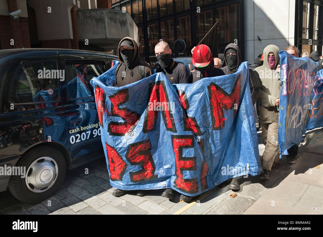 Masked anarchists and Disarm DSEi banners in city street in protest ...